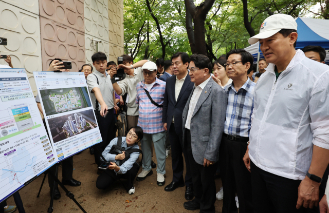 오세훈 서울시장이 4일 서울 도봉구 삼환도봉아파트 재건축사업 현장을 방문해 설명을 듣고 있다. 연합뉴스