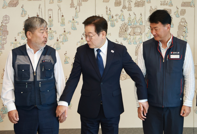이재명 대통령이 4일 김동명(왼쪽) 한국노총 위원장· 양경수 민주노총 위원장과 기념촬영을 하며 손을 잡고 있다. 연합뉴스