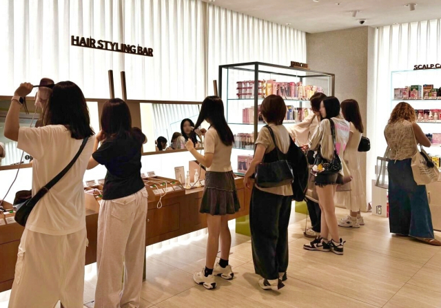 ‘올리브영N 성수’에 마련된 헤어스타일링 바에서 외국인 고객들이 헤어 기기 체험을 하고 있다. 사진 제공=CJ올리브영