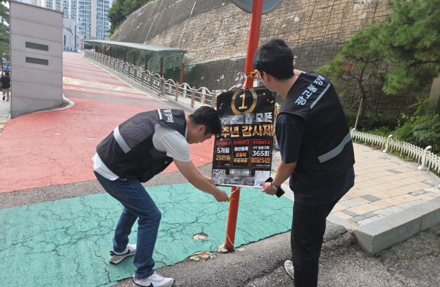 강북구청 관계자들이 어린이 통학로 근처에 위치한 불법광고물을 제거하고 있다. 사진제공=강북구