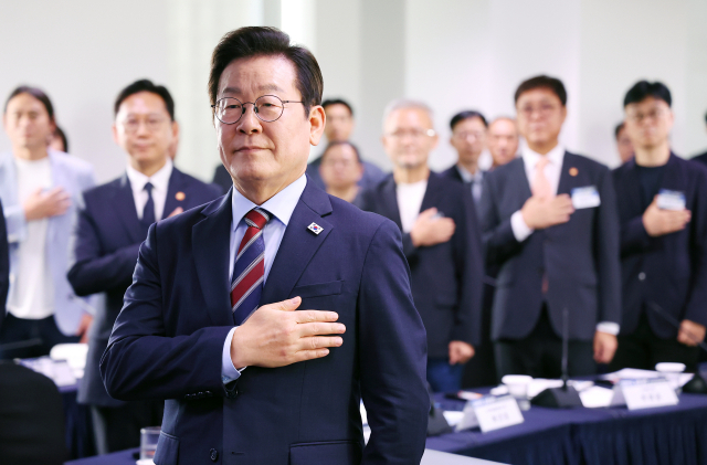 이재명 대통령이 8일 서울 중구 서울스퀘어에서 열린 국가인공지능(AI) 전략위원회 출범식에서 국기에 경례하고 있다. 연합뉴스