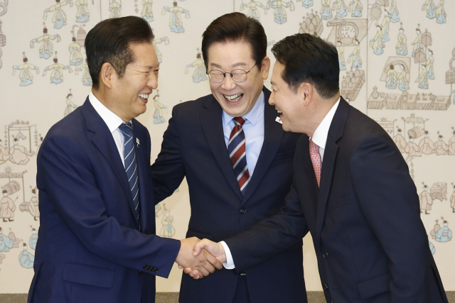 이재명 대통령이 8일 용산 대통령실에서 여야 지도부 오찬 회동에 참석한 더불어민주당 정청래 대표와 국민의힘 장동혁 대표가 악수하는 모습을 보고 있다. 대통령실통신사진기자단