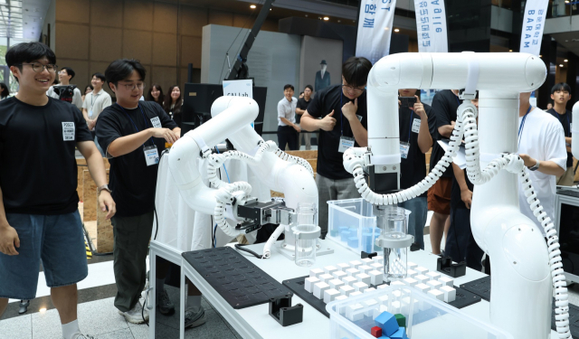 포스코홀딩스가 9일 개최한 ‘산업용 AI-로봇 경진대회’에서 참가자들이 다관절 협동로봇 챌린지를 수행하고 있다. 사진 제공=포스코홀딩스