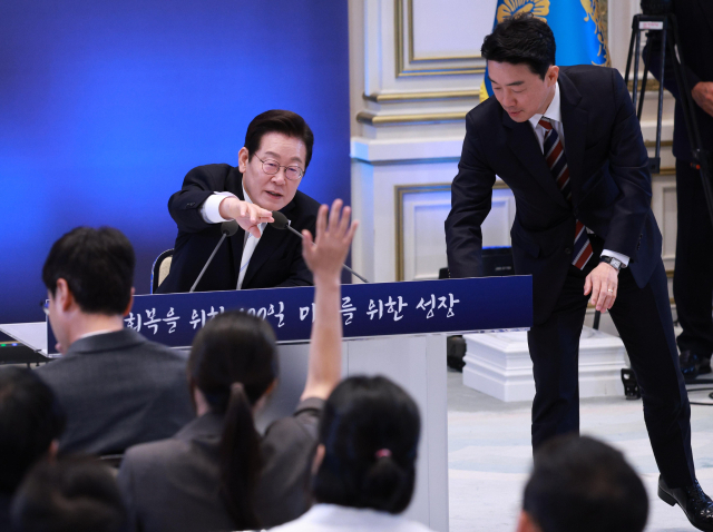 11일 청와대 영빈관에서 이재명 대통령 취임 100일 기자회견을 하던 중 이 대통령 책상 앞 판이 기울어지자 강훈식 비서실장이 정리하고 있다. 2025.9.11 [대통령실통신사진기자단]