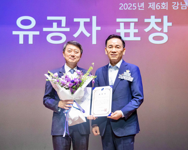 장호진(왼쪽) 현대지에프홀딩스 사장이 11일 열린 ‘제6회 강남복지포럼’에서 사회복지 부문 표창을 받은 후 조성명 강남구청장과 기념 촬영을 하고 있다. 사진 제공=현대백화점