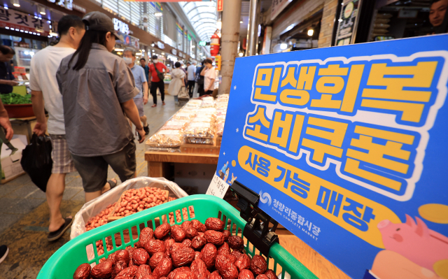 민생회복 소비쿠폰이 사용 가능하다는 판넬이 전통시장 가게 앞에 붙어 있다. 뉴스1