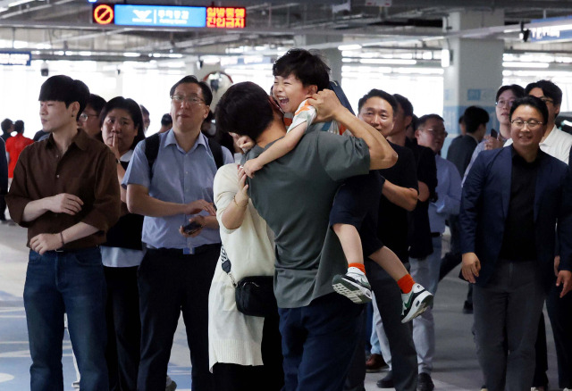 미국 이민 당국에 의해 구금됐다 풀려나 전세기로 귀국한 한국 근로자들이 12일 오후 인천국제공항 제2터미널로 입국해 지상주차장에서 가족들과 상봉하고 있다. 영종도=권욱 기자