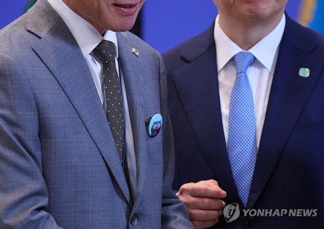 11일 청와대 영빈관에서 열린 이재명 대통령 취임 100일 기자회견에서 이규연 대통령실 홍보소통수석(왼쪽)이 이날 행사 참석자들에게 나눠준 '케이팝 데몬 헌터스' 캐릭터 '더피'로 만든 핀버튼을 가슴에 달고 있다. 연합뉴스