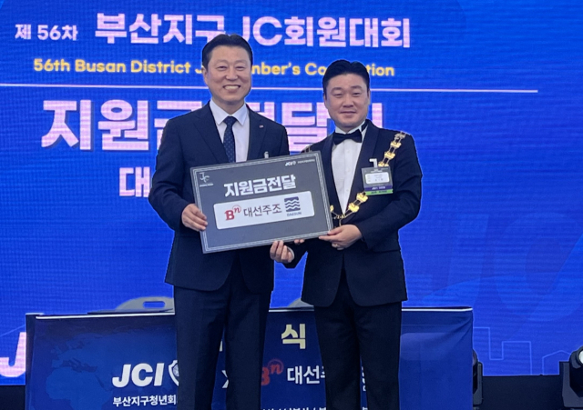 최성욱(왼쪽) 대선주조 본부장이 14일 부산 다대포해수욕장에서 홍기환 부산지구JC 지구회장에게 후원금 2000만 원을 전달하고 기념 촬영을 하고 있다. 사진제공=대선주조
