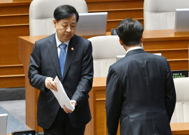 구윤철 경제부총리 겸 기획재정부 장관이 17일 서울 여의도 국회에서 열린 경제에 관한 대정부 질문에서 김상훈 국민의힘 의원의 질의에 답변하기 위해 이동하고 있다. 오른쪽은 답변을 마치고 자리로 향하는 김민석 국무총리. 성형주 기자