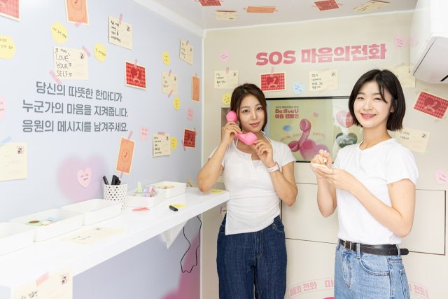 생명보험사회공헌재단 모델들이 18일 서울 중구 청계광장에서 열린 자살 예방을 위한 도심형 ‘SOS 마음의 전화’ 론칭 행사에서 마음의 전화를 소개하고 있다. 사진 제공=생명보험재단