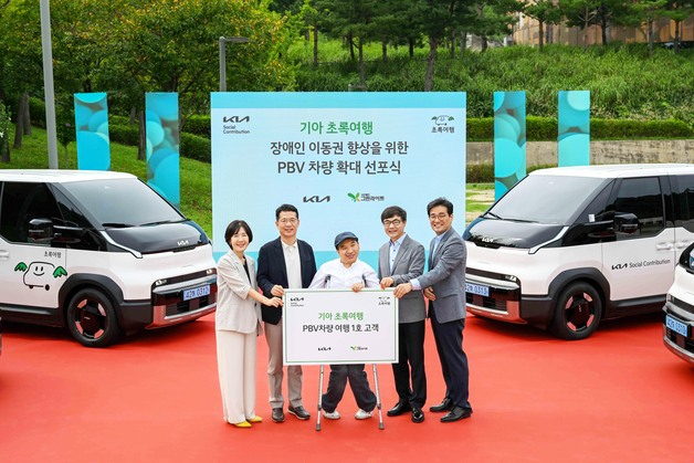 이덕현(왼쪽 두 번째) 기아 지속가능경영실장 상무와 이재강(왼쪽 네번째) 사단법인 그린라이트 회장 등 주요 관계자들이 ‘기아 PV5 여행’ 1호 고객과 기념 촬영을 하고 있다. 사진제공=기아