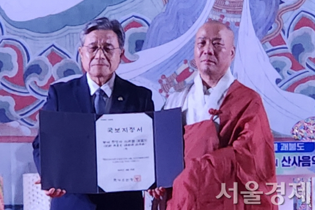 허민(왼쪽) 국가유산청장이 20일 부여 무량사에서 정덕 주지스님에게 ‘미륵불 괘불도’ 국보 지정서를 전달한 후 기념활영하고 있다. 최수문기자