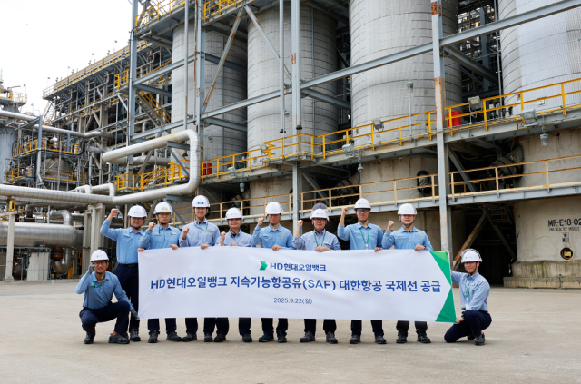 HD현대오일뱅크 관계자들이 지속가능항공유(SAF)를 생산하는 수첨분해공정 앞에서 대한항공 국제선 SAF 공급 기념 촬영을 하고 있다. 사진 제공=HD현대오일뱅크