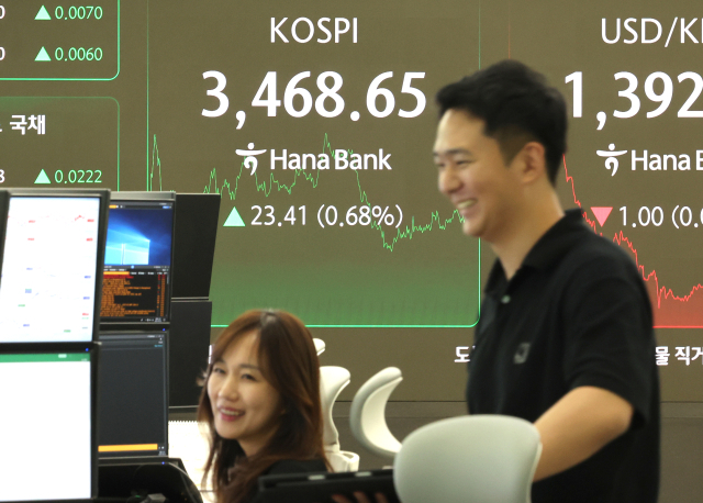 22일 서울 중구 하나은행 딜링룸에서 딜러들이 대화하고 있다. 연합뉴스