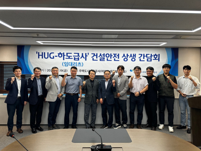 최종원(왼쪽에서 다섯 번째) HUG 기금사업본부, 김환주(왼쪽에서 여섯 번째) 대한전문건설협회 경영정책본부장, 사업장 하도급 관계자들이 19일간담회 진행 후 기념 촬영을 하고 있다. 사진 제공=HUG