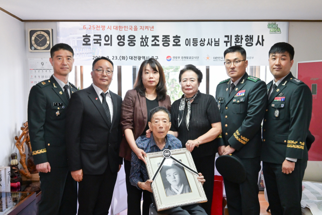 고인의 아들 조정원(가우데) 씨가 국유단 관계자, 유가족과 함께 고인의 생전 사진을 들고 있다. 사진 제공=국방부
