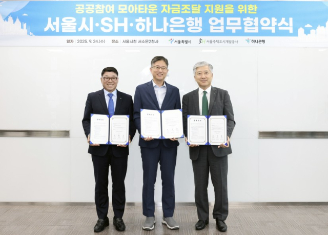 24일 서울 서소문2청사에서 최진석(가운데) 서울시 주택실장과 손오성(맨 왼쪽) 서울주택도시개발공사(SH) 전략사업본부장, 전호진 하나은행 IB그룹 부행장이 ‘공공참여 모아타운 자금조달 지원을 위한 업무협약’을 체결한 후 협약서를 들어 보이고 있다. 사진 제공=서울시