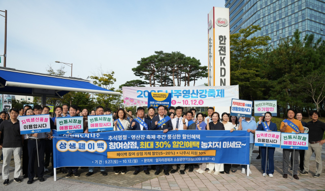 윤병태 나주시장을 비롯한 나주시 공직자, 지역 상인, 공공기관 임직원들이 지난 25일 빛가람 혁신도시 한전KDN 사거리에서 상생 페이백 행사 홍보 캠페인을 진행하고 기념촬영을 하고 있다. 사진 제공=나주시