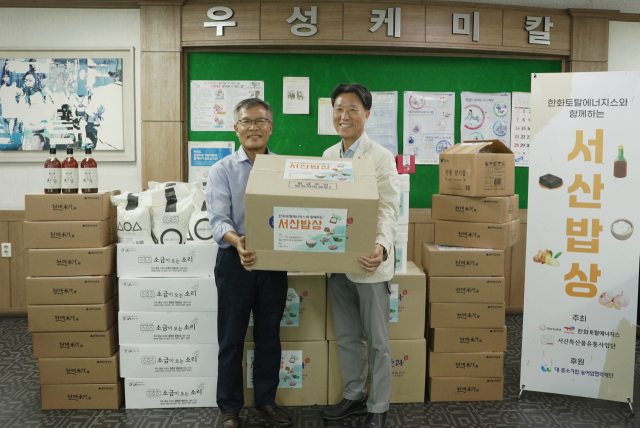 한화토탈에너지스 관계자가 25일 고객사인 우성케미칼에 서산시 농수산물을 전달하고 있다. 사진 제공=한화토탈에너지스
