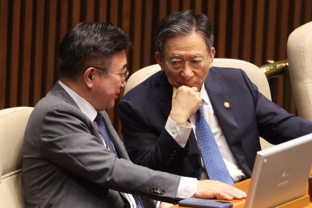 정성호 법무부 장관과 윤호중 행정안전부 장관(왼쪽)이 25일 국회 본회의에서 정부조직법 개정안 등 안건 표결에 앞서 의원석에 앉아 대화하고 있다. 연합뉴스