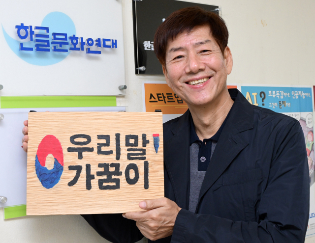정재환 한글문화연대 공동대표가 서울경제신문과 인터뷰를 마친 후 한글문화연대 사무실 앞에서 ‘우리말 가꿈이’ 팻말을 들어보이고 있다. 성형주 기자
