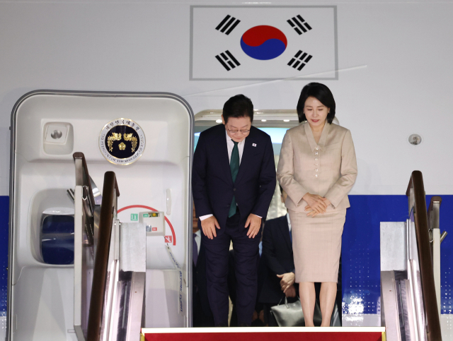 미국 방문 일정을 마치고 귀국한 이재명 대통령과 김혜경 여사가 26일 성남 서울공항에 착륙한 공군 1호기에서 인사하고 있다. 연합뉴스