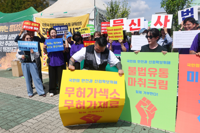대한문신사중앙회 회원들이 지난달 27일 서울 여의도 국회 앞에서 문신 합법화 촉구 기자회견을 열고 불법행위 근절 퍼포먼스를 펼치고 있다. 연합뉴스