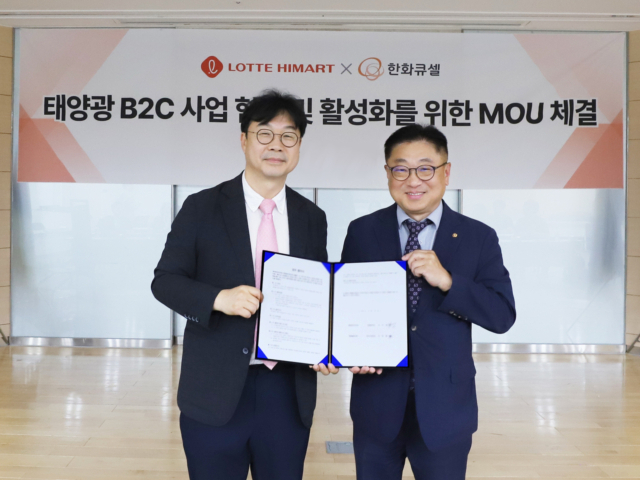 김보경(왼쪽) 롯데하이마트 상품본부장과 유재열 한화큐셀 한국사업부장이 친환경 에너지 보급 확대’를 위한 업무협약(MOU)을 체결한 뒤 협약서를 들어보이고 있다. 사진 제공=롯데하이마트