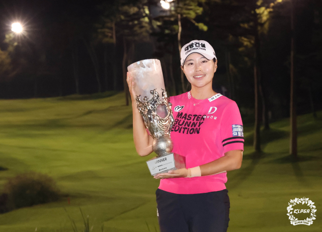 성유진이 28일 하이트진로 챔피언십에서 우승한 뒤 조명이 켜진 코스를 배경으로 트로피를 들어 보이고 있다. 사진 제공=KLPGA