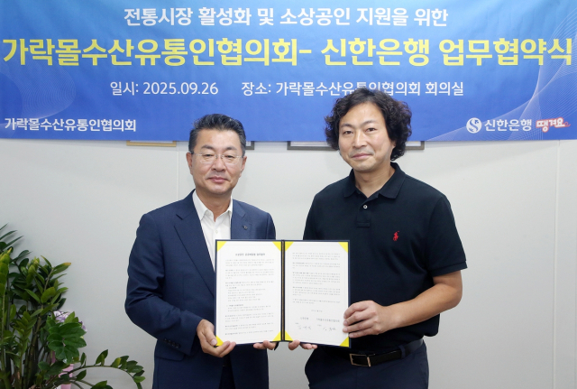 김재민(왼쪽) 신한은행 영업추진1그룹장과 김종완 가락몰수산유통인협의회 조합장이 26일 서울 송파구 가락몰에서 업무협약을 체결하고 있다. 사진 제공=신한은행