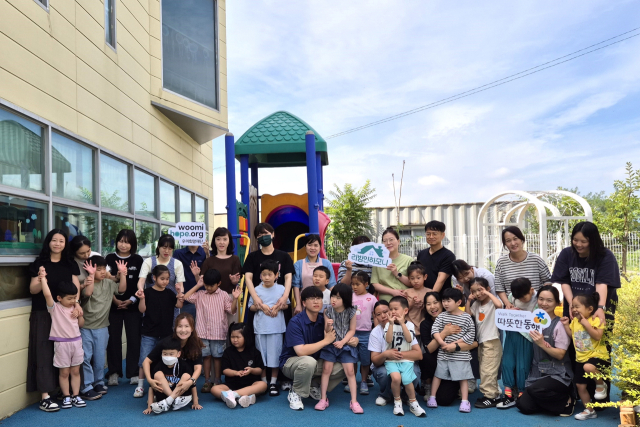 구미 하늘어린이집 원아와 교사가 ‘2025 리빙인하모니’를 통해 개선된 외부놀이공간에 모여 있다. 사진 제공=우미희망재단