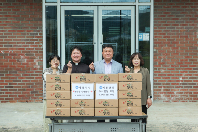 계룡건설 진중길(왼쪽에서 세번째) 상무가 청소년사회복지시설 효광원 김현(″두번째) 원장에게 위문품을 전달하고 관계자들과 기념 촬영을 하고 있다. 사진제공=계룡건설
