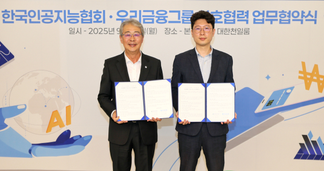 임종룡(왼쪽) 우리금융그룹 회장이 29일 우리금융 본사에서 김현철 한국인공지능협회 회장과 ‘AI산업과 금융혁신을 위한 업무협약’을 체결한 뒤 협약서를 들어보이고 있다. 우리금융그룹