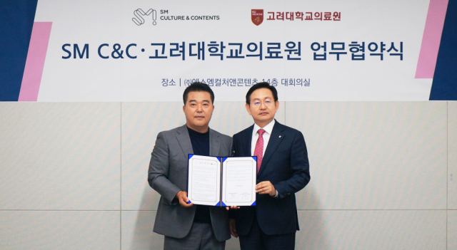 윤을식(오른쪽) 고려대의료원 의무부총장과 박태현 SM C&C 대표가 서울 성동구 SM C&C 사옥에서 업무협약식 후 기념촬영을 하고 있다. 사진 제공=고려대의료원