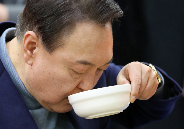 지난 2022년 당시 국민의힘 대선 후보였던 윤석열 전 대통령이 전북 군산시 군산공설시장에서 음식을 먹고 있는 모습. 뉴스1