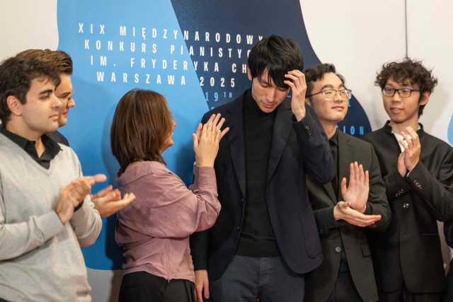 21일(현지 시간) 폴란드 바르샤바에서 열린 제19회 쇼팽 콩쿠르에서 우승한 에릭 루(왼쪽 네 번째)가 중국의 쯔퉁 왕(〃 세 번째), 미국의 윌리엄 양(오른쪽 두 번째), 중국의 텐야오 류(오른쪽) 등 경쟁자들로부터 축하를 받고 있다. AFP연합뉴스