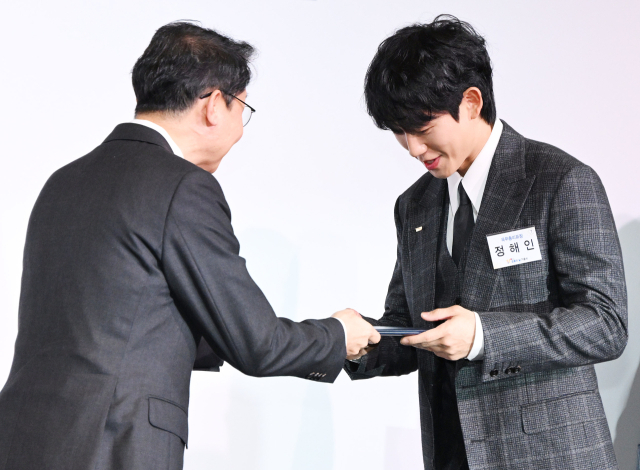 배우 정해인(오른쪽)이 28일 서울 여의도 FKI타워 컨퍼런스센터에서 열린 제10회 금융의 날 기념식에서 이억원 금융위원장에게 국무총리 표창을 수여받고 있다. 오승현 기자 2025.10.28