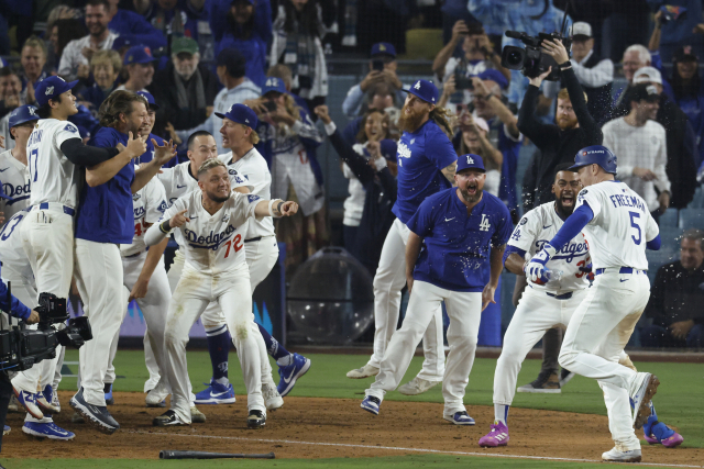 프레디 프리먼(오른쪽)이 연장 18회 말 끝내기 솔로 아치를 그린 뒤 동료들의 환영을 받으며 홈으로 들어가고 있다. EPA연합뉴스