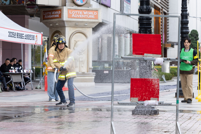 롯데월드 임직원들이 29일 서울 송파구 롯데월드 어드벤처에서 열린 '2025 소방경진대회'에서 소화전을 이용해 화재 진압 훈련을 하고 있다. 사진 제공=롯데월드