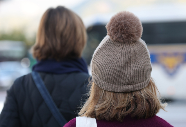 아침 기온이 전날보다 낮아져 초겨울 날씨를 보인 28일 서울 종로구 광화문광장 인근 횡단보도에서 한 시민이 모자를 쓰고 있다. 연합뉴스