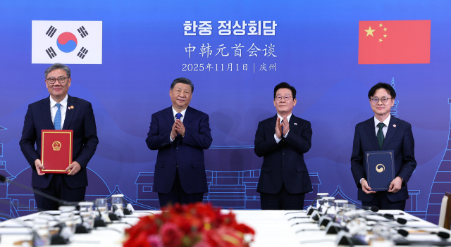 김정관(오른쪽 첫번쨰) 산업통상부 장관과 왕원타오(왼쪽 첫번째) 중국 상무부장이 1일 경북 국립경주박물관에서 이재명 대통령과 시진핑 중국 국가주석이 참석한 가운데 '서비스 무역 교류 협력 강화' 양해각서를 체결하고 있다. 연합뉴스