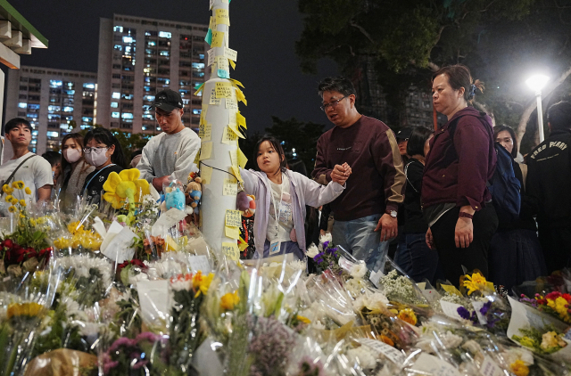 지난달 30일 홍콩 시민들이 ‘웡 푹 코트' 아파트 단지 화재와 관련해 사고 현장 인근의 한 공원에 모여 희생자들을 추모하고 있다. 이번 화재로 사망자가 속출한 가운데 중국 당국은 2019년 ‘범죄인 인도 법안(송환법)’ 반대를 계기로 벌어졌던 대규모 시위가 재연될 가능성을 우려해 반중국 행위에 대해 강력 경고하고 나섰다./로이터연합뉴스