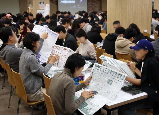 지난달 16일 서울의 한 학원에서 열린 수능 가채점 설명회에서 학부모들이 대입 지원 관련 자료를 살피고 있다. 연합뉴스