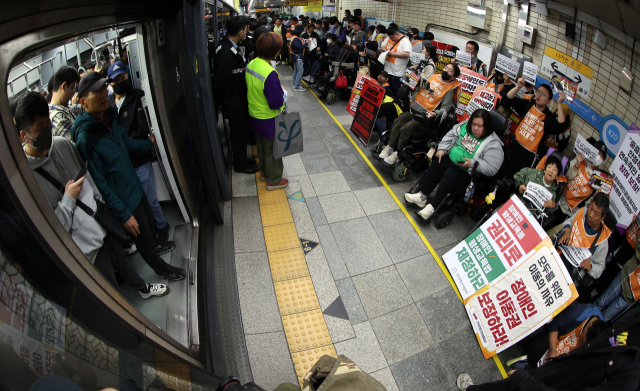 지난 5월 서울 지하철 4호선 혜화역 동대문 방면 승강장에서 열린 제62차 '출근길 지하철 탑니다' 시위에서 전국장애인차별철폐연대 회원들과 지하철 탑승 시민들이 마주보고 있다. 뉴스1