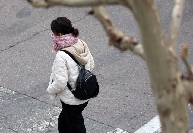 지난달 19일 오전 광주 서구 치평동에서 한 시민이 추위에 목도리를 두르고 출근길에 나서고 있다. 연합뉴스