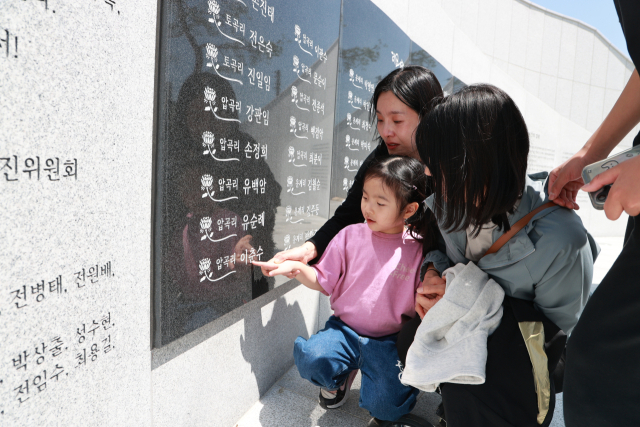 ‘4.26추모공원’을 찾은 주민들이 유족의 이름을 찾아보고 있다. 사진 제공=의령군
