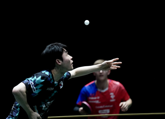 장우진(왼쪽)이 프랑스의 알렉시스 르브렁을 상대로 서브를 하고 있다. 신화연합뉴스