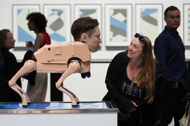 3일(현지 시간) 미국 플로리다주 마이애미비치에서 열린 ‘아트 바젤 마이애미 비치’ 행사에서 한 관람객이 예술가 비플(Beeple)의 ‘레귤러 애니멀스(Regular Animals)’라는 설치 작품 속 일론 머스크를 닮은 로봇을 바라보고 있다. AP연합뉴스