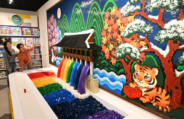 4일 서울 용산구 아이파크몰 용산점 리빙파크 6층에서 열린 공식 레고스토어 용산점 프리 오픈 행사에서 모델들이 광화문과 근정전을 구현한 레고 작품을 관람하고 있다. 권욱 기자 2025.12.4